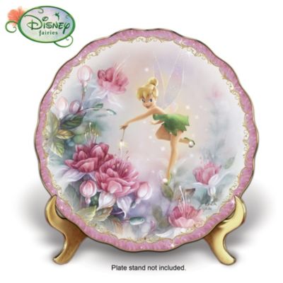 Every garden needs a fairy or two to coax and care for the abundant blooms, but this special garden has magic all its own with Disney's Tinker Bell! Introducing Bradford Exchange's first-ever Disney Tinker Bell collector plate with Lena Liu floral art. Tiny little Tink adds a gentle touch of pink to the magnificent flowers envisioned by none other than award-winning Hall-of-Fame artist Lena Liu - and the result is pure enchantment!This unique home decor is a sweet combination of Tinker Bell's precious charms and artist Lena Liu's sumptuous flowers that will add a beautiful touch to any room. Rimmed in rich 22K gold, this gently scalloped porcelain collector plate shimmers with the look of pixie dust for unique home decor that will make you a believer! Hurry to bring home this special first for your collection or give as a collectible Tinker Bell gift that won't soon be forgotten. Strong demand is expected and you won't want to miss out. Order now!