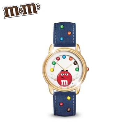 No matter how busy your schedule is, there's always time to fit in your favorite chocolate candies. Now you can let M&M'S&reg; super cool Red Character help you stay on track each day with this adorable first-of-a-kind M&M'S character watch, a fine jewelry design exclusively from The Bradford Exchange.This fun and fashionable M&M'S-themed jewelry is handcrafted in stainless steel with a gold-tone trim and features rotating "candies" and a colorful red M&M lentil on its face. Finely engraved on its reverse side is the charming message, "There's always time for M&M'S." For the perfect finishing touch, a denim cloth watchband with colorful "candy" accents completes this delightful keepsake. Strong demand is expected and you won't want to miss out. Order now!