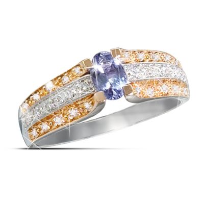 The alluring, mysterious beauty of the Tanzanite first came to light in 1967, and to this day is found only in mines deep beneath Mt. Kilimanjaro in Africa! Now you can acquire this prized gemstone in a yellow gold and white gold Tanzanite ring that captures this prized gemstone at its best, in a fine jewelry exclusive from The Bradford Exchange. Tanzanite's amazing range of colors - combining the cool blue of sapphire and the rich purple of amethyst - have made this gemstone a fashion trend-setter, and this unique ring design surrounds the stone with 30 diamonds for the ultimate statement of luxury.Exquisitely crafted in 10K solid gold with alternating rows of yellow and white gold, the centerpiece of this stunning ring is a faceted oval Tanzanite gemstone with amazing blue-violet luminescence that flashes from every facet. A spectacular array of 30 genuine diamonds set into the 3 rows of multi-colored gold create a dazzling effect that is simply breathtaking. Sure to turn heads wherever it is worn, this yellow gold and white gold Tanzanite ring is expected to generate high demand. It's a unique ring design not to be missed, so order now!