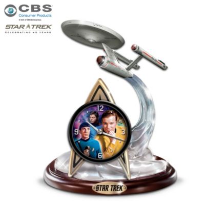 STAR TREK has captivated our wildest imagination from the first moment we were invited "To boldly go where no man has gone before." Now you can mark the minutes and hours in exciting STAR TREK style with a handcrafted tabletop STAR TREK clock, available exclusively from The Bradford Exchange.The Final Frontier STAR TREK clock is officially licensed and authenticated and is the first-ever to feature a flawless replica of the U.S.S. Enterprise NCC-1701 rising on a galactic trail of clear crystalline. Beneath the Starship, a sleek quartz-driven clock rests upon an official Starfleet Delta symbol gleaming in metallic tones. Hour and minute hands of modern design circle the face, which is graced by classic images of Captain Kirk, Mr. Spock and Dr. McCoy against a celestial background. Very strong demand is expected, so don't delay. Order at warp speed!