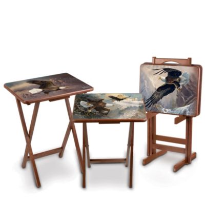 Enjoy a magnificent view when you use this beautiful first-ever bald eagle art tray table set featuring highly-collectible images by award-winning wildlife artist Ted Blaylock. Each of the 4 full-color tray tables showcases a different compelling image of majestic eagles in flight, swooping from lofty peaks to rugged canyons.  This decorative, convenient and sturdy table set is exclusively from The Bradford Exchange. The wooden tables have a lustrous cherry finish to complement your decor. They're convenient for every day use and elegant enough for entertaining. Tables are heat- and moisture-resistant for lasting beauty and years of enjoyment. When not in use, just store them in the convenient storage stand, yours FREE with the set. High demand is expected from Ted Blaylock fans, so order now!