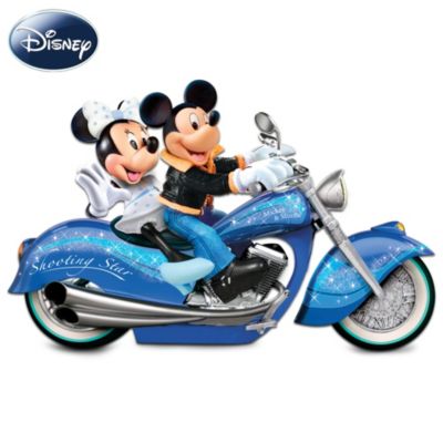 Since Steamboat Willie in 1928, it's been quite a ride for Mickey and Minnie in love! But these days, a tug boat just won't suffice for the darlings of Disney. Rev up some excitement with this Mickey and Minnie motorcycle sculpture, an original design from The Bradford Exchange featuring the couple riding a motorcycle in sparkling style!Measuring a generous 14 inches in length, the Mickey and Minnie: Star Power Masterpiece Motorcycle is handcrafted in artist's resin, hand-painted and accented with silvery handles and real metal foot pedals. A swirling stardust pattern from front to back conveys that unique sense of Disney magic, while the headlight and tail light really illuminate! Plus, an animated sound of a motorcycle engine revs up at the touch of a button. Edition is limited to 5,000. Strong demand is expect, so don't delay. Order now! A fine collectible, not intended for children.
