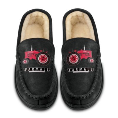 Are you ready to step out for a celebration of the tractor that helped grow America? Now you can show off your pride for an American farming institution with this Farmall apparel exclusive from The Bradford Exchange. We are proud to introduce a sharp pair of custom-designed Farmall moccasins for men, an impressive way to share the rich history of an American farming icon.Handcrafted of black suede uppers and durable rubber soles, these Farmall moccasins are versatile enough to wear as slippers or shoes, and they are lined with plush faux shearling for ultimate comfort. Artwork of the famed Farmall tractor embellishes the top of each moccasin, so every step you make demonstrates your Farmall pride in perfect style. Strong demand is expected, so don't wait to secure yours - order now!