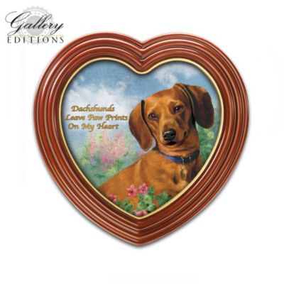 Your Dachshund knows just how to brighten each day with a simple wag of his tail! Now, celebrate the special bond you share with this Gallery Editions limited-edition Dachshund wall decor art featuring an adorable portrait of a sweet Dachshund by acclaimed artist Linda Picken.Available exclusively from The Bradford Exchange, Ms. Picken's beloved Dachshund art is masterfully printed on gallery-quality canvas with the endearing message "Dachshunds Leave Paw Prints On My Heart" in golden script. For added delight, this Dachshund art wall decor is presented in a custom-designed, heart-shaped frame enriched with a deep mahogany finish and golden trim. Makes a perfect addition to your own home decor, or give as a heartfelt Dachshund lover gift. Strong demand is anticipated, so don't delay. Order now!