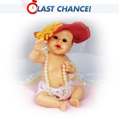 She's all dressed up just like a big girl, and ready to warm her way into your heart! It's easy to fall in love with this miniature baby doll by acclaimed Master Doll Artist Sherry Rawn. This gorgeous little girl is comes complete with accessories and a coordinating blanket. She has expressive features including big, beautiful eyes, rosy cheeks and a cute little mouth. Baby sits with one arm extended, as if she's reaching for you. This darling diva is dressed in pretty lace panties, a strand of "pearls," and a floppy, red hat with a big flower off to one side.This pretty little poser is exclusively from The Ashton-Drake Galleries. She's expertly recreated in resin, then hand-painted for attention to realistic detail. Comes with a FREE blanket featuring the phrase "This is My Good Side!" and lace trim. Strong demand is expected for this resin baby doll, so order now!