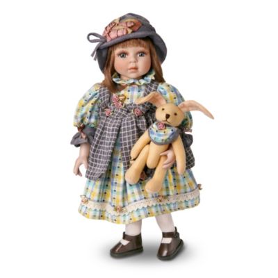 Carrie never goes anywhere without her lop-eared playmate. Why, she even coordinates her beloved bunny's outfit to match her own! A collectible vintage-style porcelain doll rekindles memories of playtime pals. Carrie is dressed in an ensemble that includes a brightly-colored dress with floral trim and bows, a checkered pinafore and coordinating hat.Celebrate special childhood friendships with this remarkable real porcelain 17-inch collectible doll, available exclusively from The Ashton-Drake Galleries. Carrie's hand-painted face is even more adorable thanks to her hand-set eyes and long eyelashes. Exceptional demand is expected for this charming little girl doll, and you won't want to miss out. Order now!