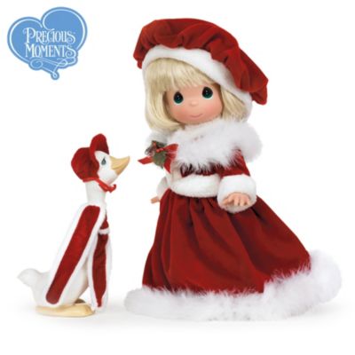 Enjoy a pretty miss and her treasured pet, all dressed up and ready to mark the holidays in jolly-holly style! This collectible Precious Moments&reg; blonde vinyl doll goose friend was inspired by artist Sam Butcher's cherished Precious Moments characters.Celebrate the joys of loving, caring and sharing with this enchanting Precious Moments doll, from The Ashton-Drake Galleries. Fully crafted in collector-quality vinyl from head to toe, this collectible Precious Moments Santa-inspired doll wears a flowing red gown and beret trimmed with "fur" and feathery accents. Even her faithful goose companion wears a coordinating ensemble. Exceptional demand is expected for this strictly limited edition of just 500 . Order now!