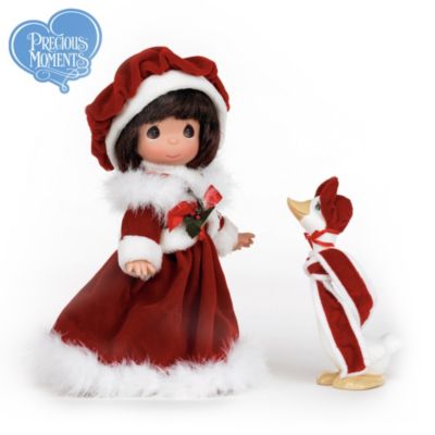 No one knows the pleasures of loving, caring and sharing better than artist Sam Butcher's Precious Moments&reg; characters. Now, a collectible Santa-inspired Precious Moments brunette vinyl doll and her goose friend celebrate Christmas kindness and generosity. This lovely lass and her faithful, web-footed pal are costumed in matching red-and-white outfits that pay tribute to the jolly fellow himself!Available from The Ashton-Drake Galleries, this charming collectible Precious Moments brunette vinyl doll is entirely crafted in collector-quality vinyl to create remarkable details like the girl's tender expression, warm eyes and joyful smile. This strictly limited edition of just 500 is expected to generate strong demand. Don't wait - order now!