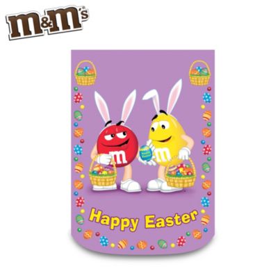 Chocolate and Easter just go together. Now you can show off your springtime "good taste" with this first-ever M&M'S&reg; decorative Easter flag! A Hamilton Collection exclusive, this delightful M&M'S characters home decor features both Plain and Peanut M&M'S characters all dressed up for Easter and carrying colorful, candy-filled Easter baskets. With its pastel purple background, the flag is the perfect Easter home decor to welcome the holiday - and spring itself. This eye-catching M&M'S outdoor flag is constructed of durable, fade-resistant waterproof polyester and is machine washable for years of holiday enjoyment. Very strong demand is expected, so don't wait until these flags are all gobbled up. Order now!