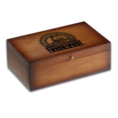 Your Hawthorne Village trains need a safe place to park. Now, you can keep them preserved in style with this charming wood train storage box, available exclusively from Hawthorne Village, A Bradford Exchange Company.Handcrafted of rich, mahogany-stained solid wood, this heirloom-quality storage case is built to last with interlocking finger-joints for a snug fit and clean look. Two cushioned trays inside provide a place for eight train cars, and one tray is removable for extra convenience. Plus, the Hawthorne Village Masterpiece Railways logo graces the front of this keepsake while antiqued metal hardware adds a nostalgic look. Strong demand is expected for this Hawthorne Village train storage box. Order now!