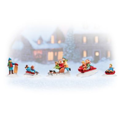 The sound of laughter is everywhere as these rosy-cheeked children zoom down the snow-blanketed hill aboard their trusty sleds. What could be finer on a winter's day than joining your friends and sledding, sledding, sledding until your cheeks are apple red and you hear a cup of hot cocoa calling your name? Now, you can accessorize your holiday village with a 5-piece set of handcrafted collectible Hawthorne village accessories with children at play. Enhance your Hawthorne village collection with the simple innocence of those carefree childhood days when winter was a joyous friend with a 5-piece village figurine accessory set. Brisk demand is expected for these hand-painted collectible village accessories that can be arranged to create perfect accents to your favorite village celebrating the joys of childhood. Available only from Hawthorne Village and you won't find a finer value anywhere. Order now!