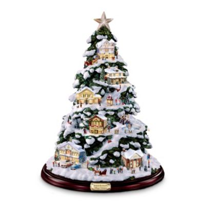 Light up your holidays with this extraordinary Norman Rockwell collectible illuminated Christmas tree! It's starting to look a lot like the holidays in this tiny village, inspired by Norman Rockwell's beloved hometown of Stockbridge. Each tiny building glows with light from within, nestled amongst the snow-sparkled evergreen boughs of this village Christmas illuminated tree, and surrounded by bustling villagers, lampposts, a gazebo, even a skating pond! This exclusive, limited-edition illuminated Norman Rockwell collectible tabletop Christmas tree from The Bradford Editions is filled with amazing details - look, you can see Mr. Rockwell through the window of his studio! Fans of Norman Rockwell's heartwarming work are sure to be thrilled by this first-ever Rockwell collectible, so don't wait - Order now!