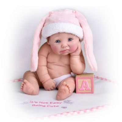 Enjoy a gallery's worth of gorgeous baby "portraits" with attitude to spare. You will be delighted with this collection of lifelike collectible resin baby dolls. Each doll comes with a matching blanket and adorable accessories. Beginning with Issue One, It's Not Easy Being Cute, soon you'll lose your heart to Issue Two, Princess in Training and Issue Three, I Want a Pony. Before you know it, your collection will continue with additional cute baby dolls, each a separate issue to follow.An exclusive from The Ashton-Drake Galleries, the realistic baby dolls in this collection are charmingly chubby and showcased in heart-melting poses. What's more? Each of these dolls by artist Sherry Rawn wears a custom-designed hat and arrives with a FREE coordinating blanket. The blanket is imprinted with a sentiment that is sure to make you smile. But don't delay - heavy demand is expected, because Issue One is the winner of the 2009 DOTY (Doll of the Year) Industry Choice Award! and you don't want to miss out. Order now!