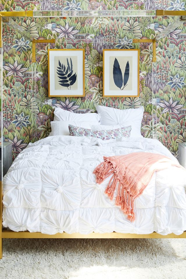 Whimsical blue, purple and green wallpaper in a bedroom with a modern acrylic bed and indigo fern wall art - Anthropologie. #bedroomdecor #indigoblue