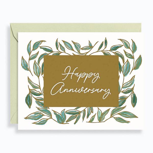 Anniversary greeting card decorated with illustrated leaves and gold foil. Card reads, happy anniversary.