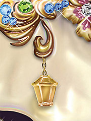 Dangling from the posh pachyderm's ear is a Thomas Kinkade signature golden lantern